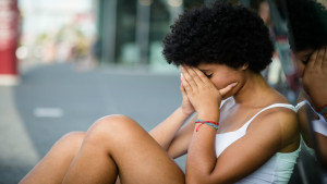 Disappointed teenage girl covering her face with hands